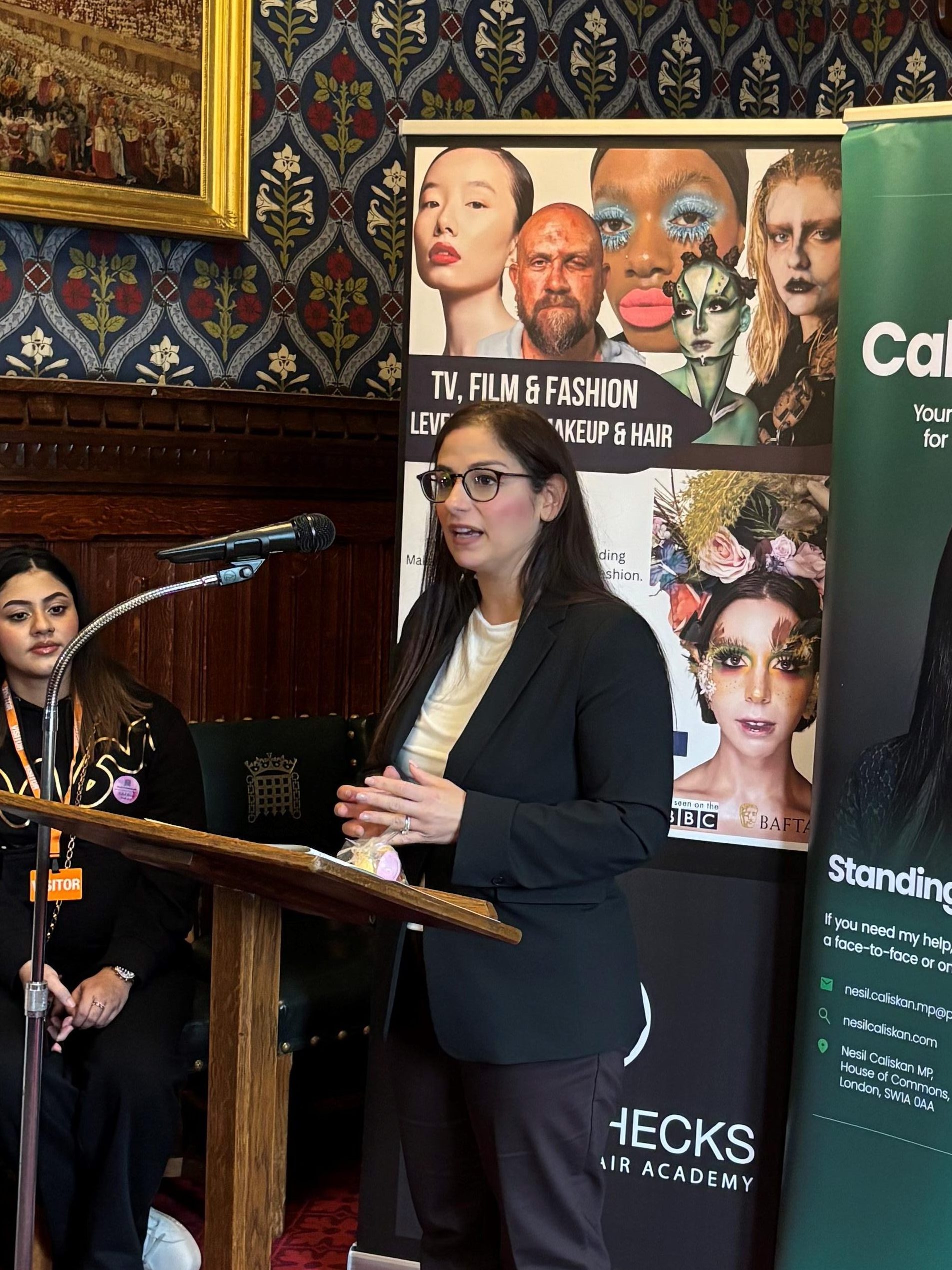 Nesil Caliskan, Barking MP, speaking to guests at her Beauty Week reception in Parliament in front of a lecturn.